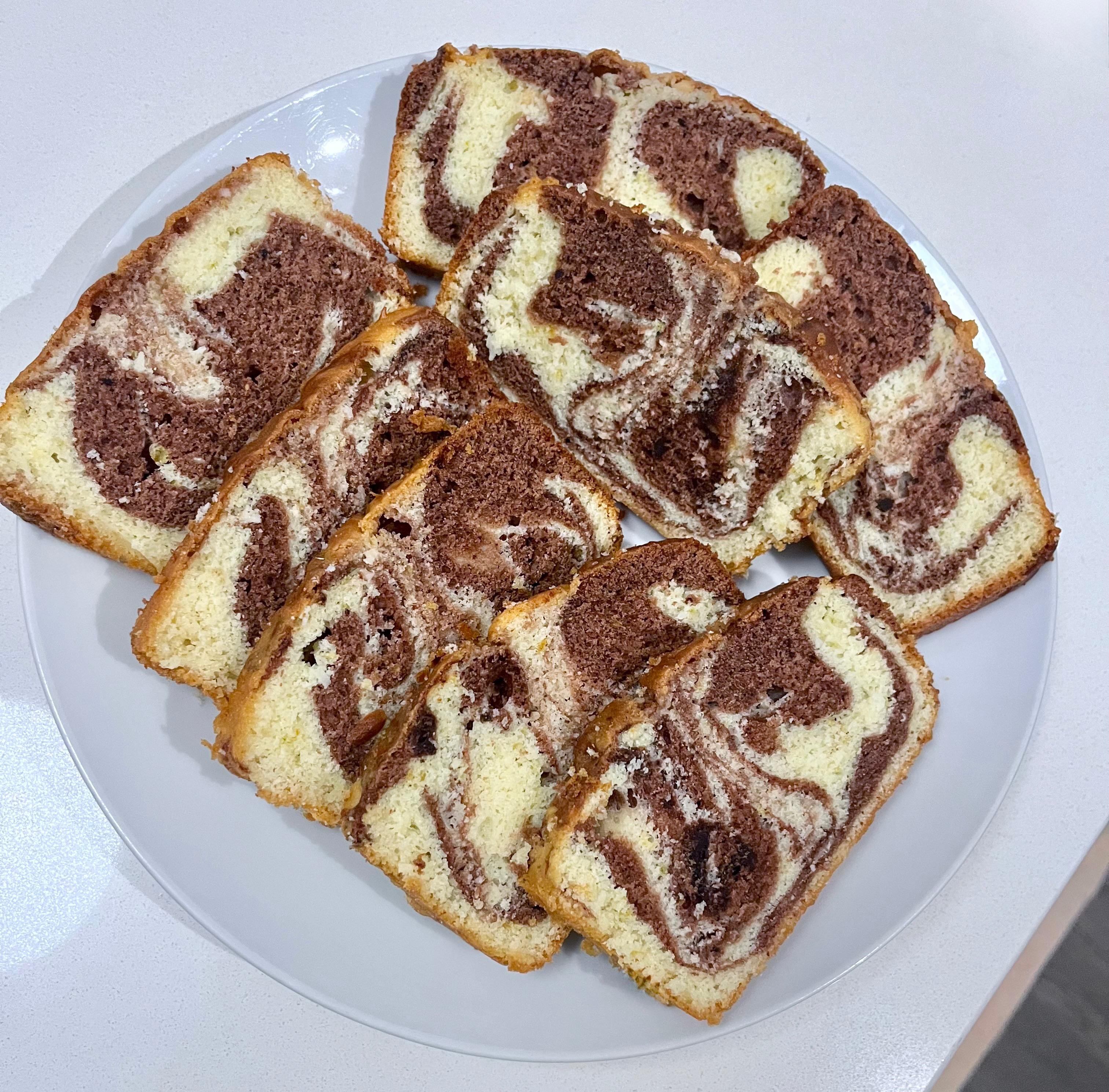 Slices of homemade marble cake with chocolate and vanilla swirls arranged on a white plate